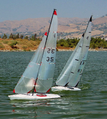 Two sailboats are sailing on the water.
