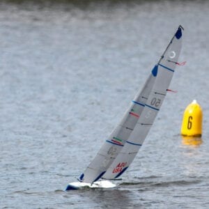 A sailboat is in the water near a buoy.