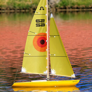 A yellow sailboat floating on top of water.
